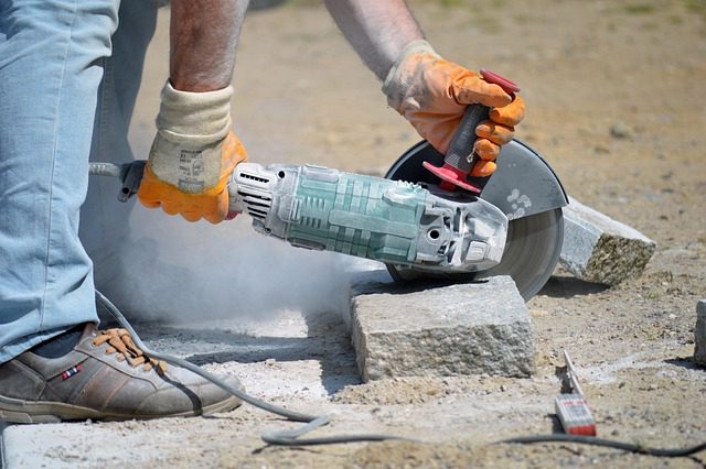 A worker cutting a slab for direct bury trenching